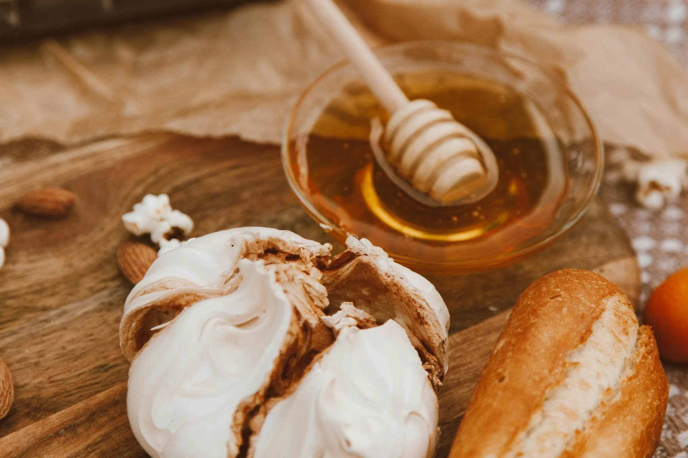 Garlic bulbs next to a jar of honey and bread